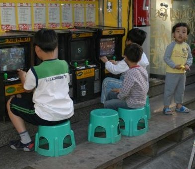kleine Koreaanse spelletjesfanaten op kleine spelautomaten